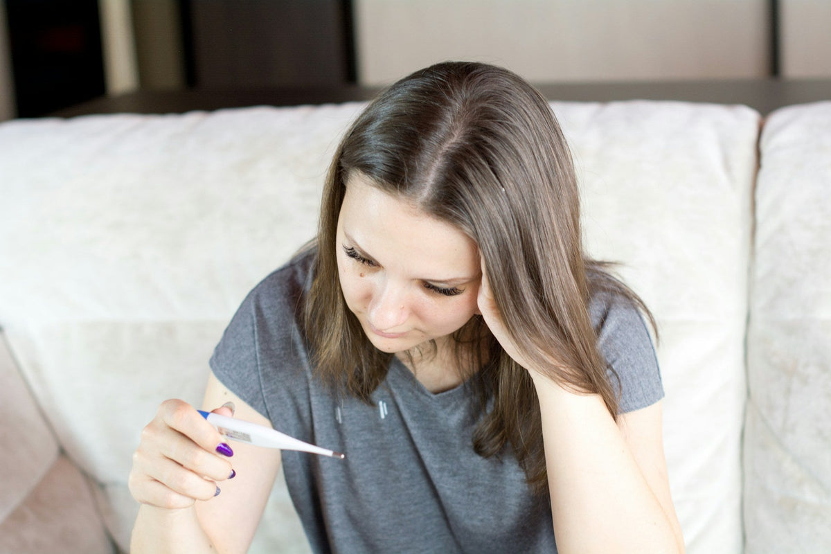 Woman holding thermometer in hands